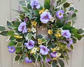 Corona primaveral morada y amarilla. Corona artificial de verano para la puerta. Decoración para la puerta con flores moradas y bayas verdes. Adorno para la puerta de una casa nueva.