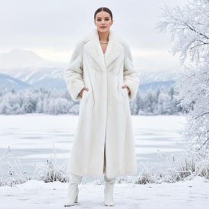 May include: A full-length, white faux fur coat with a wide collar and pockets. The coat is worn with white boots. The background features a snowy landscape with a frozen lake and mountains.