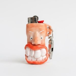 Chaveiro porta-isqueiro feito à mão em argila polimérica, porta-isqueiro com carinha engraçada, chaveiro de arte surreal, presente inusitado, acessório exclusivo feito à mão.