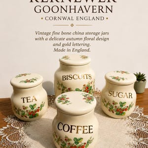 May include: Four vintage fine bone china storage jars with lids. Each jar is cream-colored with a delicate autumn floral design and gold lettering. The jars are labeled "TEA", "BISCUITS", "SUGAR", and "COFFEE". The text "KERNEWEK GOONHAVERN" is at the top.