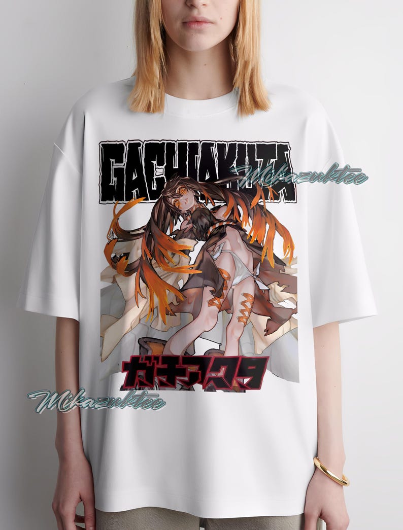 May include: White t-shirt featuring a graphic design with the text "GACHIAKITA" above and Japanese text below. The graphic depicts two figures with long hair and orange accents.