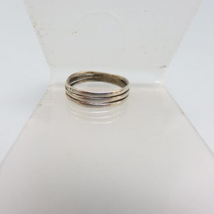May include: A silver ring with three bands.