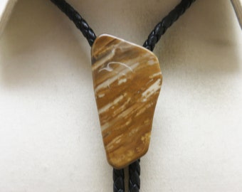 May include: A brown and white patterned bolo tie with a black braided cord.