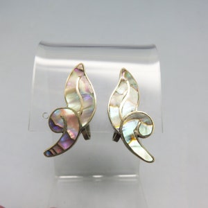 May include: A pair of silver clip-on earrings with a leaf design. The leaves are made of iridescent mother-of-pearl and have a gold outline.