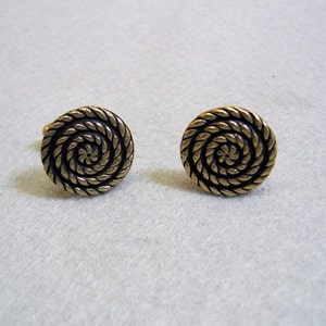 May include: A pair of gold-toned cufflinks with a black spiral design.