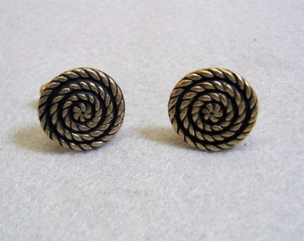 May include: A pair of gold-toned cufflinks with a black spiral design.