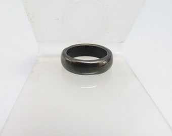 May include: A simple black ring with a smooth, polished finish.
