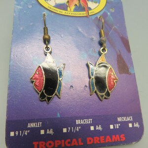 May include: A pair of dangle earrings featuring a black, red, and blue fish design. The earrings are on a white card with the text "TROPICAL DREAMS" and "TROPICAL ACCESSORIES INC."