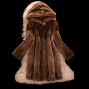 May include: A brown fur coat with a hood and a light-colored fur trim. The coat has a gold-colored clasp at the chest. The coat is displayed against a black background.