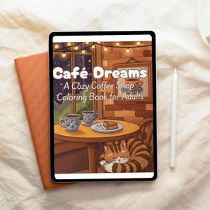 Puede incluir: Una tableta digital muestra la portada de un libro para colorear titulado "Café Dreams: A Cozy Coffee Shop Coloring Book for Adults". La ilustración presenta una escena de cafetería con un gato durmiendo, tazas de café y una mesa.