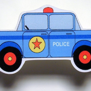 May include: A blue toy police car with a red star on the side and the word "POLICE" printed on the door. The car has a red light on top.