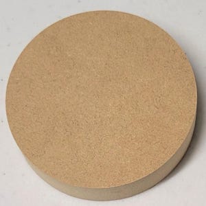 May include: A round, light brown coaster with a textured surface. The coaster is made of a composite material and has a simple, minimalist design. The edges are smooth and the overall shape is a perfect circle.