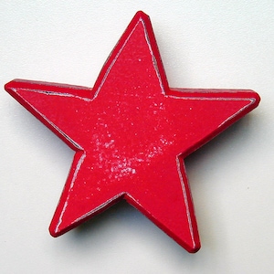 May include: A red wooden star with a distressed finish. The star is a simple, five-pointed design.