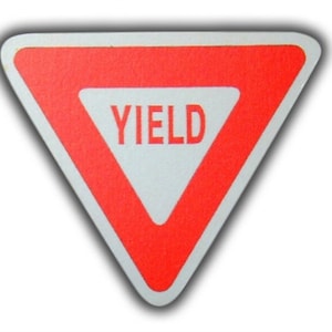 May include: A red triangular yield sign with white lettering that reads "YIELD".