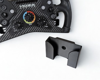 May include: A black racing wheel with the text "MOZA RACING" and a black mounting bracket. The wheel has multiple buttons and dials, and a carbon fiber pattern. The bracket is rectangular with a circular hole.