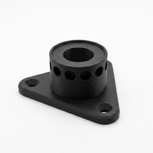 May include: A matte black triangular mounting bracket featuring a central cylindrical post with a hollow core. The base has three countersunk screw holes at each corner, and the cylindrical section includes a ring of small circular perforations.
