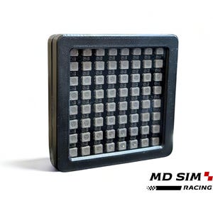 May include: A black square electronic device with a grid of small, square, illuminated lights. The device has a black frame and the text "MD SIM RACING" is visible in the lower right corner.