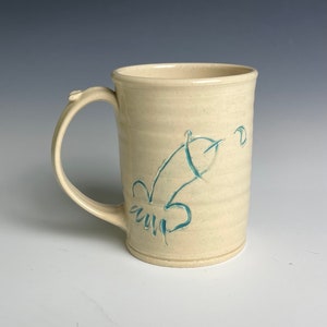 May include: A white ceramic mug with a blue design of a stylized bird on the side.