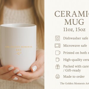 Op de afbeelding: Een witte keramische mok met een oor, vastgehouden door een persoon. De mok heeft de tekst "THE GOLDEN MOMENTS ART" in gouden letters. De afbeelding bevat ook de tekst "CERAMIC MUG" en "11oz, 15oz".
