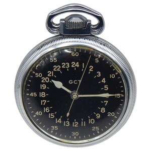 K&ouml;nnte beinhalten: Eine Vintage-Taschenuhr mit schwarzem Zifferblatt und silberfarbenem Geh&auml;use. Die Uhr hat wei&szlig;e Ziffern und Zeiger und eine 24-Stunden-Anzeige. Sie hat eine Krone und eine &Ouml;se zur Befestigung einer Kette.