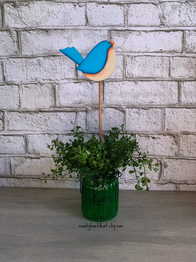 Hand painted Eastern bluebird plant poke, made from wood and painted in shades of blue and cream.  Displayed in a houseplant.  For indoor use only.