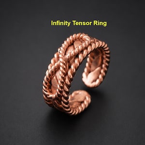 May include: A copper-colored metal ring featuring a twisted rope-like texture and an open-ended design. The text Infinity Tensor Ring is displayed above the object. The ring has a metallic finish with a repeating braided pattern throughout.