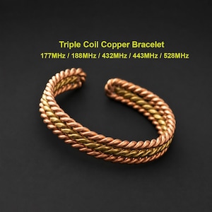 May include: A triple coil copper bracelet featuring two outer copper-toned twisted strands and a central brass-toned twisted strand. The text Triple Coil Copper Bracelet 177MHz / 188MHz / 432MHz / 443MHz / 528MHz is displayed above the bracelet.