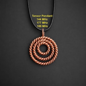 May include: A copper-colored metal pendant featuring three concentric circles made of twisted wire, suspended from a black cord. The text "Tensor Pendant 144 MHz 177 MHz 188 MHz" is printed in yellow above the pendant on the dark background.