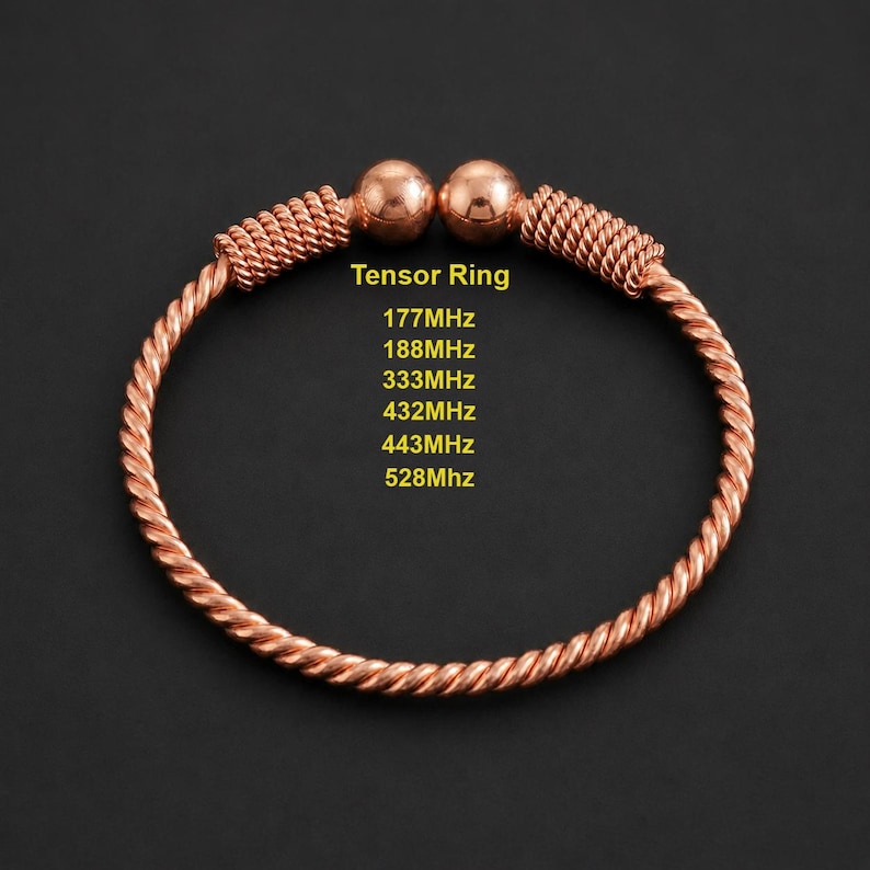 May include: A copper-colored metal bracelet featuring a twisted wire design with two spherical ends. The text "Tensor Ring" is printed in yellow, followed by a list of frequencies: 177MHz, 188MHz, 333MHz, 432MHz, 443MHz, and 528MHz in yellow text.