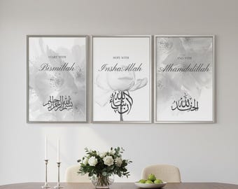 May include: Three framed art prints with floral backgrounds and Arabic calligraphy. The prints are in a row, each with a different phrase in English and Arabic. The frames are gray, and the overall color scheme is black, white, and gray.
