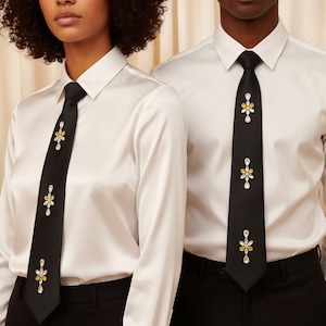 Könnte beinhalten: Zwei Personen tragen schwarze Krawatten mit floralen Verzierungen. Die Krawatten haben ein sich wiederholendes Muster aus gelben und klaren Edelsteinen. Sie werden mit weißen Hemden und schwarzen Hosen kombiniert.