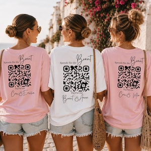 Può includere: Tre donne indossano magliette oversize con testo e codici QR sul retro. Due magliette sono rosa e una è bianca. Il testo include "Braut", "Spende für die" e "Paypal me".