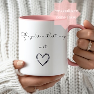 Può includere: Tazza in ceramica bianca con interno e manico rosa. La tazza presenta le parole "Pflegedienstleitung mit" e un simbolo a forma di cuore in grafia nera. È visibile una grafica a stella rosa con testo.