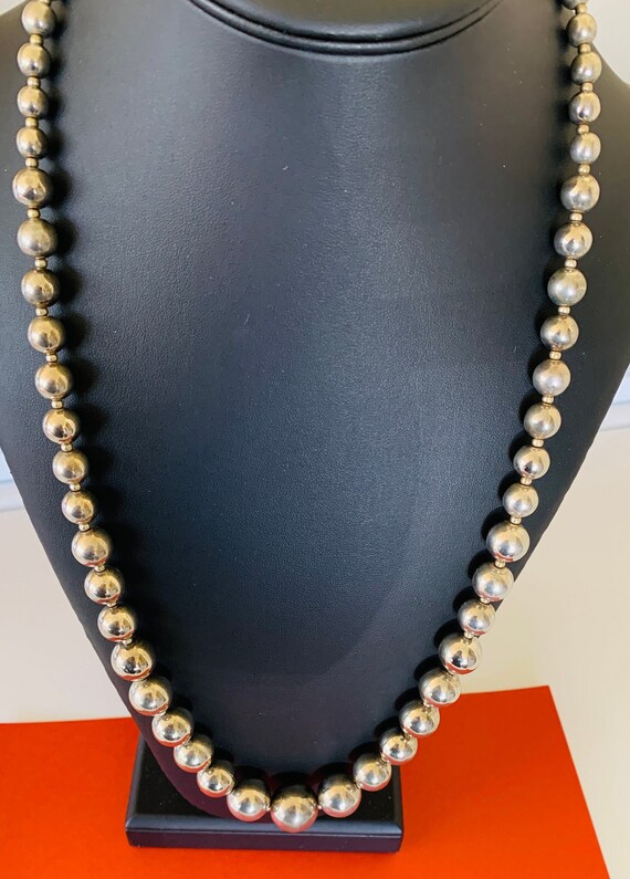 Silver tone graduated chain strung bead over the h