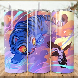 Puede incluir: Tres vasos aislados de acero inoxidable con un dise&ntilde;o envolvente que presenta un tigre azul, un p&aacute;jaro y un cielo colorido. Cada vaso tiene una pajita transparente y una tapa plateada. El fondo es una superficie de madera.