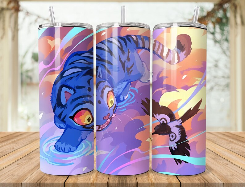 Puede incluir: Tres vasos aislados de acero inoxidable con un dise&ntilde;o envolvente que presenta un tigre azul, un p&aacute;jaro y un cielo colorido. Cada vaso tiene una pajita transparente y una tapa plateada. El fondo es una superficie de madera.