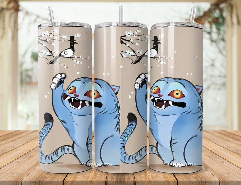 Puede incluir: Tres vasos de acero inoxidable con un dise&ntilde;o de gato de dibujos animados. El gato es azul con ojos amarillos y la boca abierta. El fondo es de color beige claro con un p&aacute;jaro en una rama.