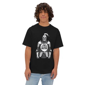 May include: Black t-shirt with a graphic of a knight's armour and the text "I FART IN YOUR GENERAL DIRECTION". The design is in white and grey tones. The shirt is made of a soft, comfortable material.