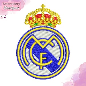 Pode incluir: Patch bordado com o brasão do Real Madrid. O design inclui um emblema circular azul e amarelo com as letras "RM" e "F", encimado por uma coroa dourada. O texto "Embroidery Designs" está em uma caixa rosa no canto superior esquerdo.