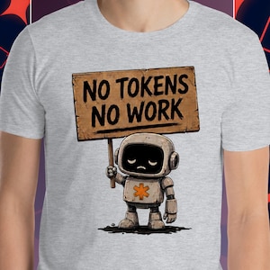 以下が含まれることがあります： 「NO TOKENS NO WORK」と書かれた看板を持つ漫画のロボットが描かれた、明るい灰色のTシャツ。 ロボットは黒い画面の顔をしており、胸には星のようなシンボルがあります。