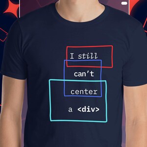 Può includere: T-shirt blu navy con la scritta "I still can't center a <div>" in un design a strati. Il testo è all'interno di rettangoli rossi, blu e turchese. La maglietta è a maniche corte.