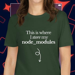 以下が含まれることがあります： 「This is where I store my node_modules」の白文字が入った濃い緑色のTシャツ。白い矢印が下を指しています。半袖のカジュアルなトップスです。