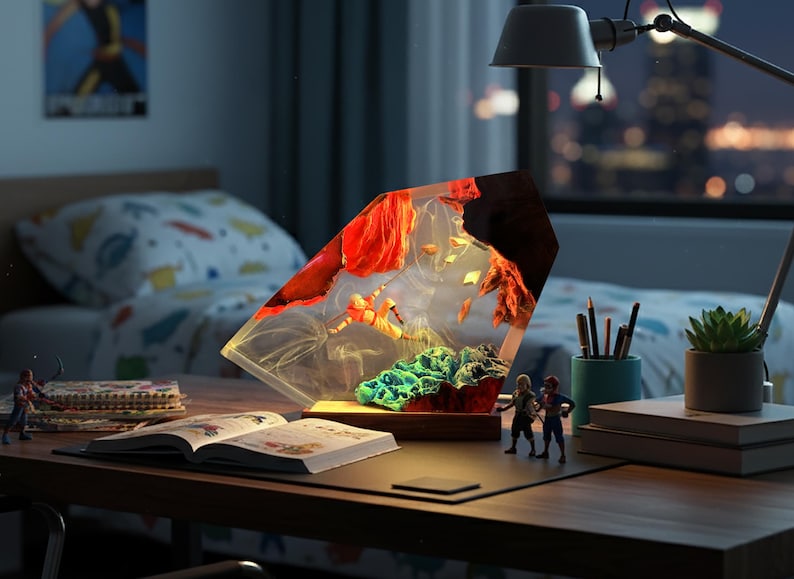 May include: A decorative lamp with a unique design, featuring a clear, angled resin structure filled with colorful elements. The lamp sits on a wooden base, with a desk lamp and cityscape visible in the background.