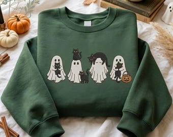 May include: A forest green crewneck sweatshirt featuring an embroidered graphic of four white ghosts, each interacting with black cats. One ghost holds a cat, another has a cat on its head, one has a cat on its back, and one holds a pumpkin bucket.