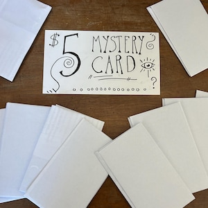 May include: A rectangular white card with black hand-drawn text that reads $5 MYSTERY CARD, featuring a spiral design, an eye icon, and question marks, surrounded by several plain white envelopes arranged in a scattered pattern.
