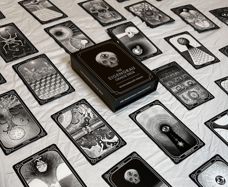 May include: A black oracle deck box with the text "THE EIGENGRAU ORACLE DECK" and several black and white oracle cards. The cards feature detailed illustrations and are spread out on a white surface.