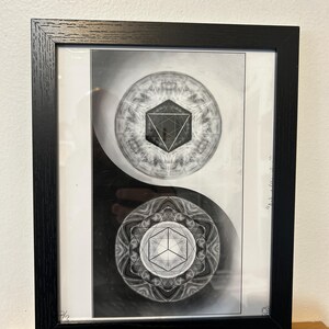 May include: A black and white framed print featuring a yin-yang composition. The top circle contains a geometric triangle within a mandala pattern, while the bottom circle displays a cube within a similar intricate circular design.