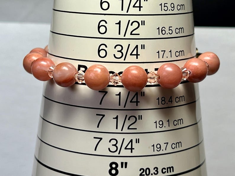 May include: A pink and clear beaded bracelet measuring 7 1/4 inches or 18.4 cm in circumference. The bracelet is made with round pink beads and clear crystal beads.
