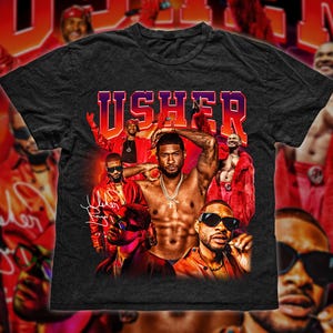 Può includere: T-shirt nera con una stampa grafica di Usher e altre persone. Il testo "USHER" è stampato in grandi lettere bianche sulla maglietta.