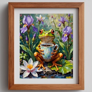 Peut inclure: Une impression d'art encadrée représente une grenouille verte aux yeux rouges tenant une tasse à thé bleue et blanche remplie de café. La grenouille est entourée d'iris violets, d'un nénuphar blanc et de verdure. L'œuvre est dans un cadre en bois.